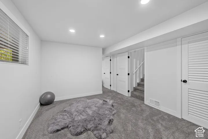 Recessed lighting illuminates the carpeted flooring
