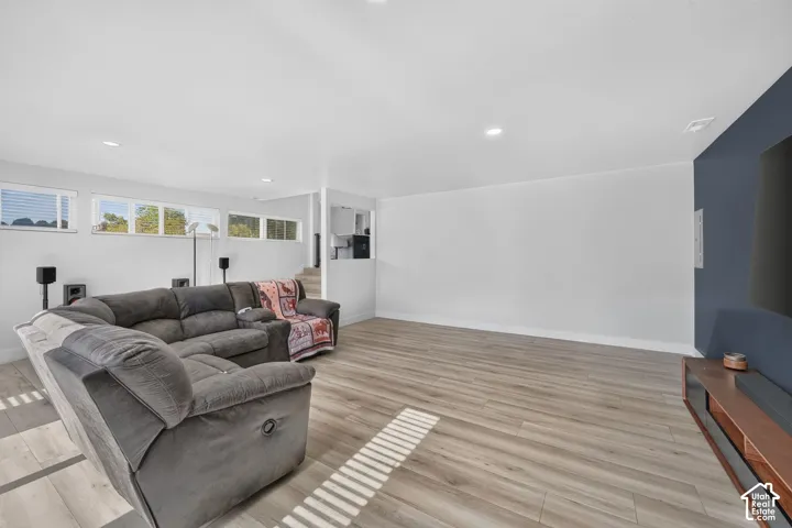 Recessed lighting, light wood-finish flooring, white walls, and a feature wall