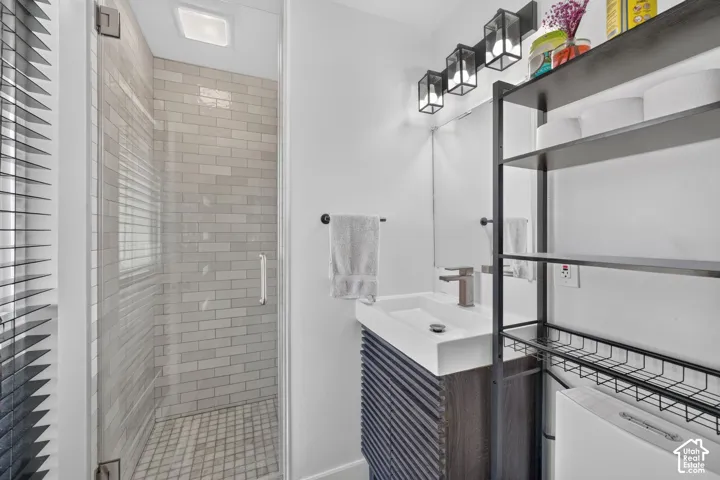 Glass-enclosed shower with subway tile surround and mosaic tile floor