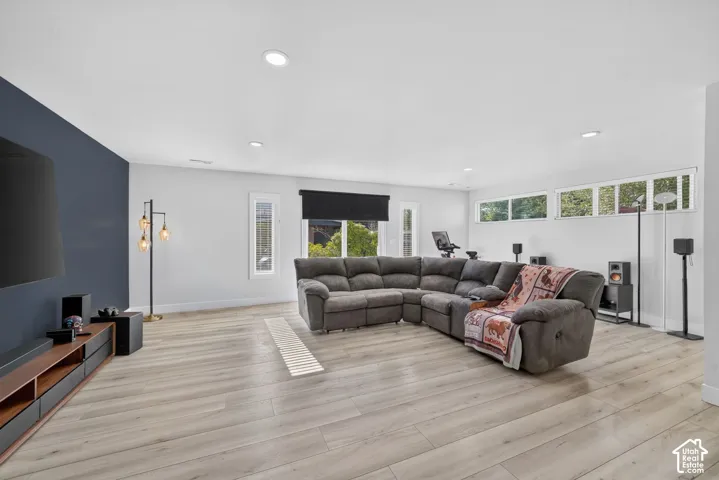 Spacious room featuring wood-finish flooring, recessed lighting, and multiple windows