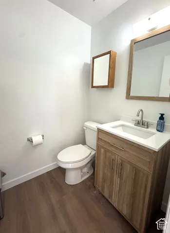 Modern vanity with wood-finish cabinetry, integrated sink, and white countertop