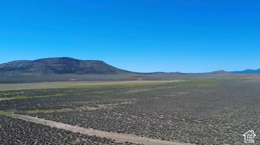 Expansive undeveloped land featuring natural terrain and distant mountains