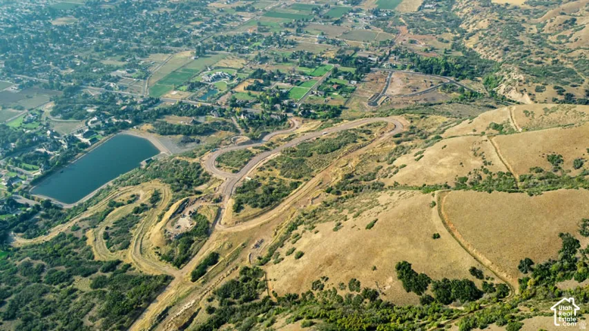 Expansive elevated terrain with surrounding verdant landscape and a prominent body of water