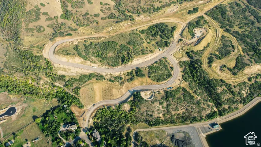Expansive land parcel featuring established roadways, varied topography, and direct access to a substantial body of water
