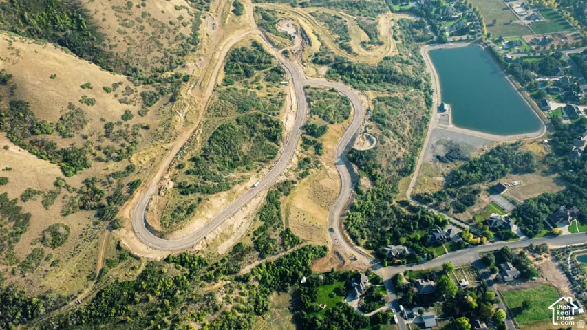Curved roadways traversing varied terrain, reservoir with surrounding green space, and established residential areas