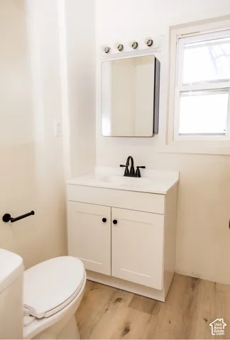 White vanity with shaker-style doors, black hardware, and a single basin sink featuring a matte black faucet