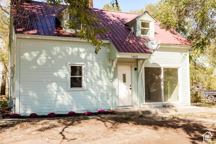 Light blue horizontal siding facade with a red metal roof