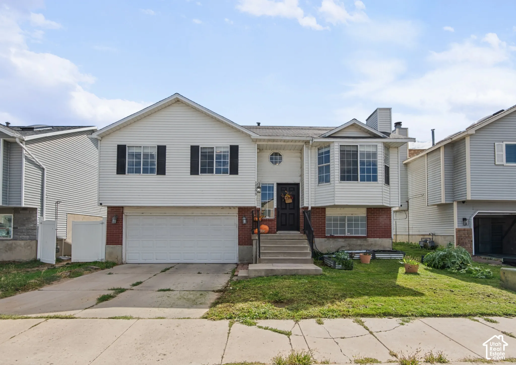Two-story residence featuring white siding and a brick-finish lower level
