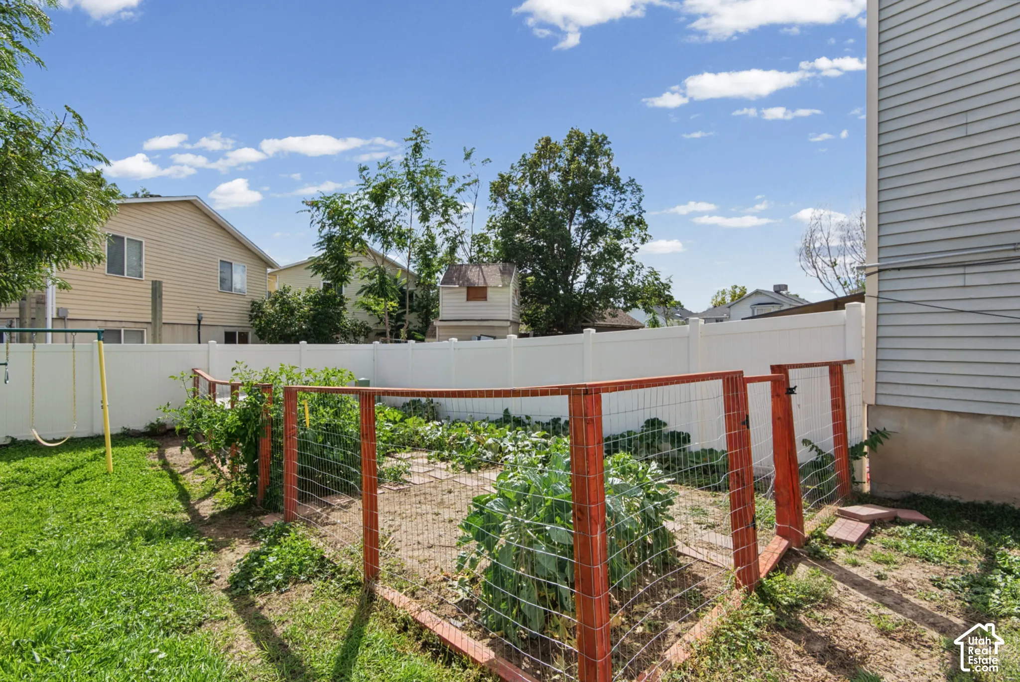 Fenced garden area, manicured lawn, and privacy fencing
