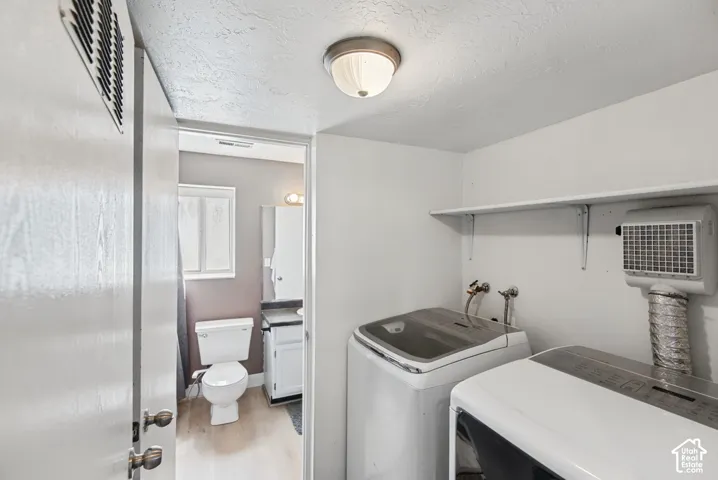 Dedicated laundry area with wall-mounted shelving and ceiling-mounted light fixture