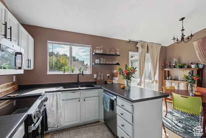 Kitchen featuring white cabinetry, black countertops, a stainless steel oven/range, and a center island