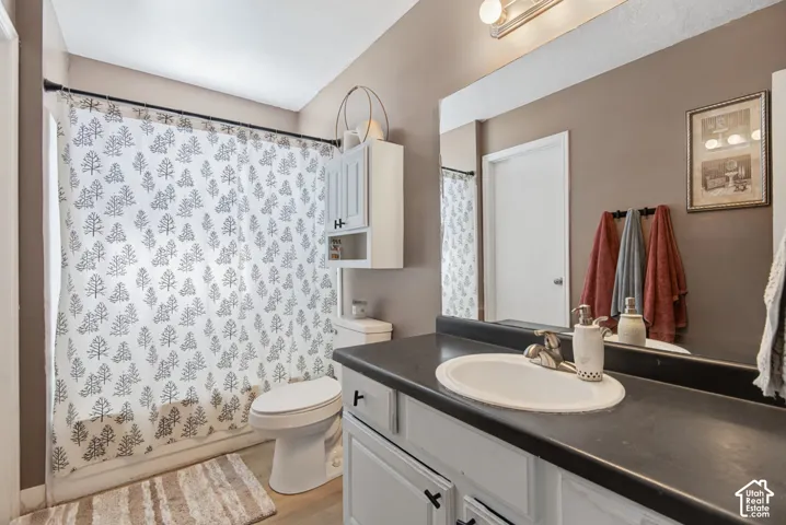Vanity with white cabinetry, a single basin sink, and dark countertop