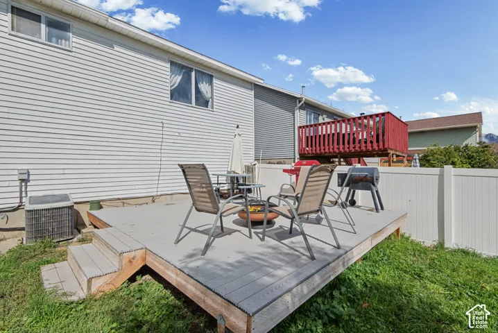 Exterior wood-finish deck with steps, white privacy fencing, and wood siding