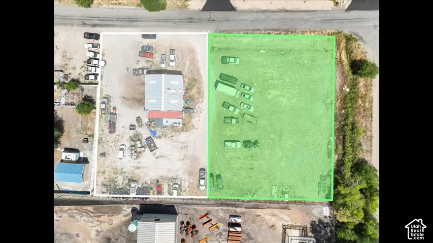 Expansive lot featuring a large building with a metal roof and an additional outbuilding