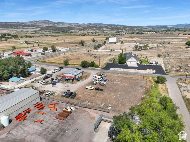 Property featuring a multi-building complex with a large paved parking area and an adjacent undeveloped parcel