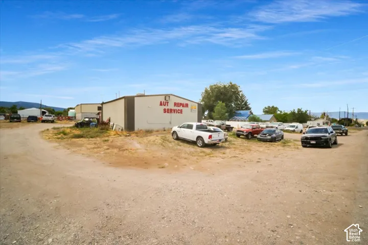 Commercial building with "AUT REPAIR SERVICE" signage, surrounded by an unpaved lot