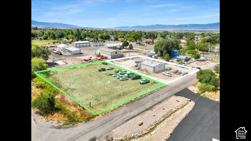 Expansive land parcel featuring direct road access and surrounding commercial structures