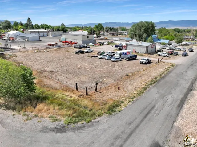 Expansive undeveloped parcel featuring a perimeter fence and paved road frontage