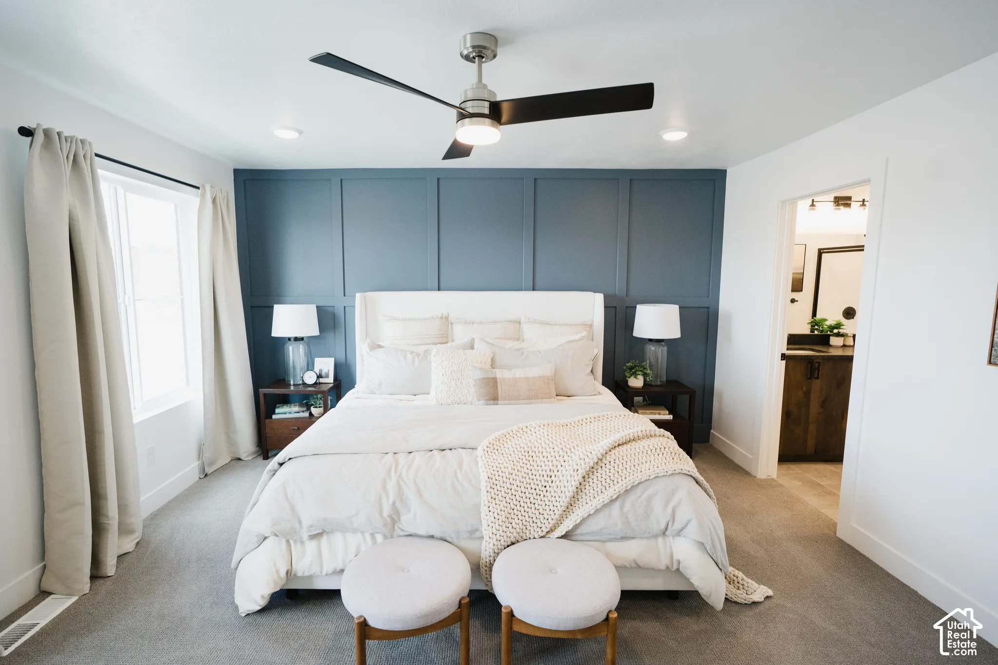 Accent wall with grid paneling, recessed lighting, ceiling fan, carpet flooring, and a window with roller shades