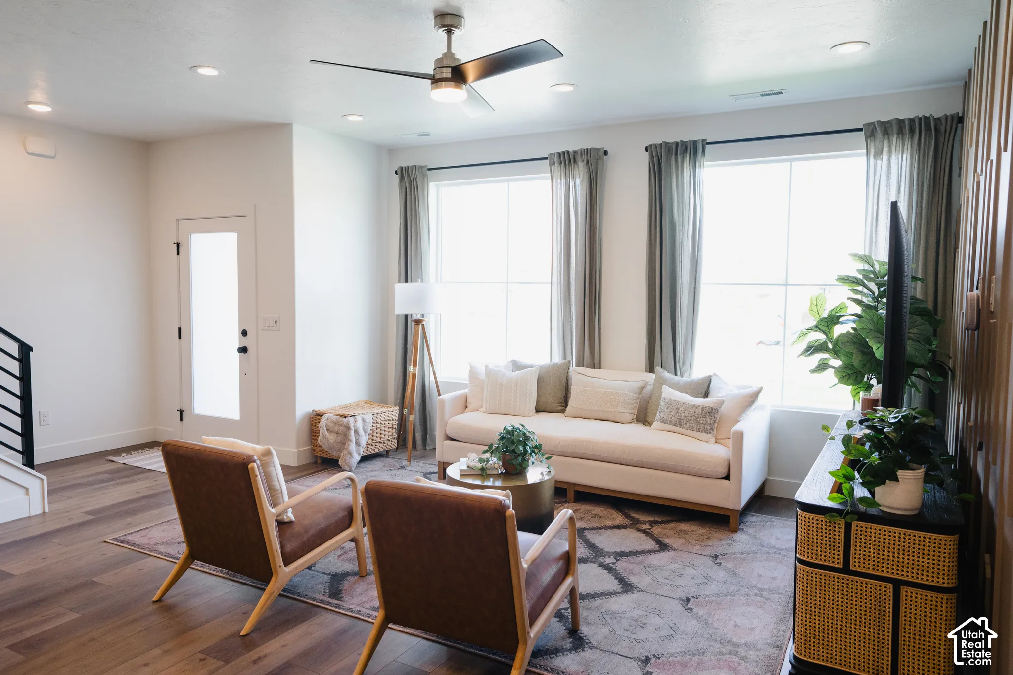 Open-concept living area with wood-finish flooring, recessed lighting, and a contemporary ceiling fan