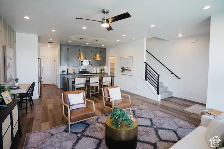 Open-concept living area featuring wood-finish flooring, recessed lighting, and a modern ceiling fan