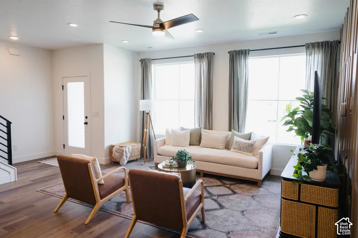 Open-concept living area with wood-finish flooring, recessed lighting, and a contemporary ceiling fan