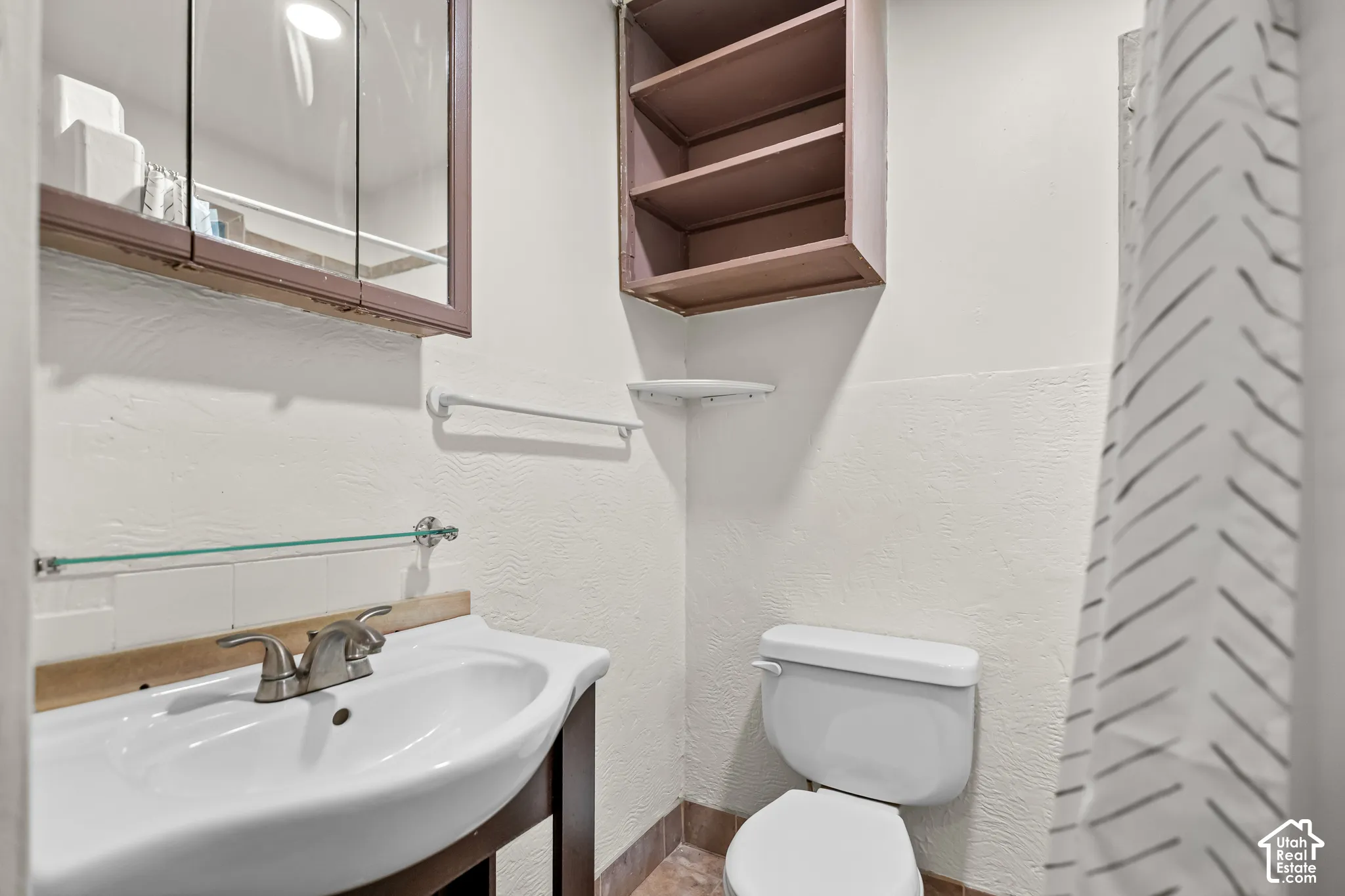 White vanity with an integrated sink and a brushed nickel faucet