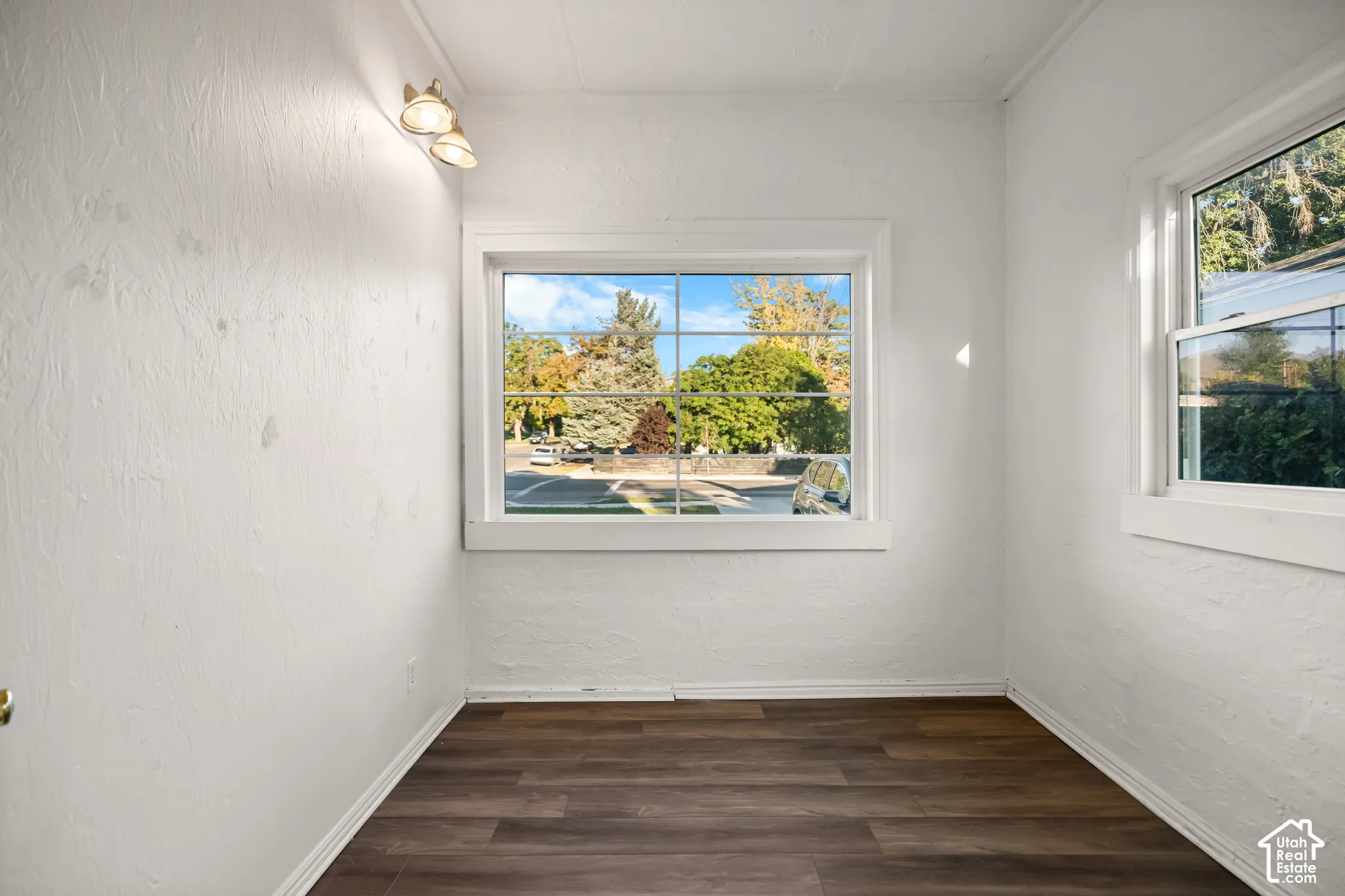 Wood-finish flooring with white trim and white walls