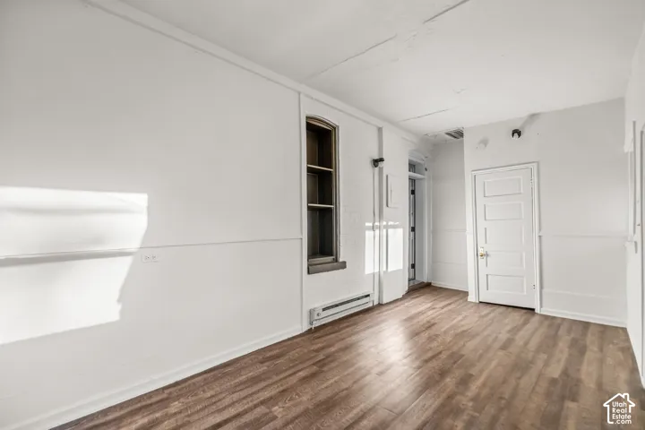 Wood-finish flooring, white walls, and a multi-pane window