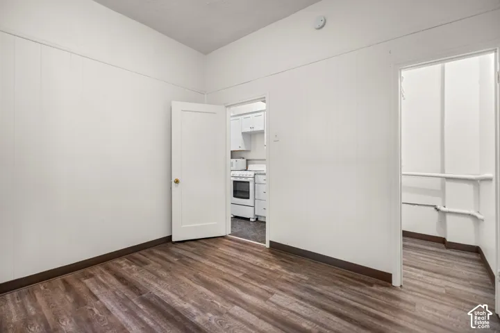 Wood-finish flooring with white paneled walls and a white ceiling