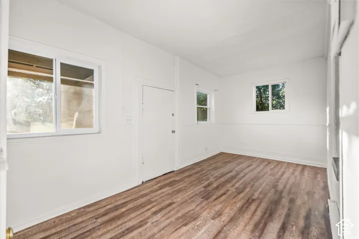Wood-finish flooring, multiple windows, and a ceiling-mounted light fixture