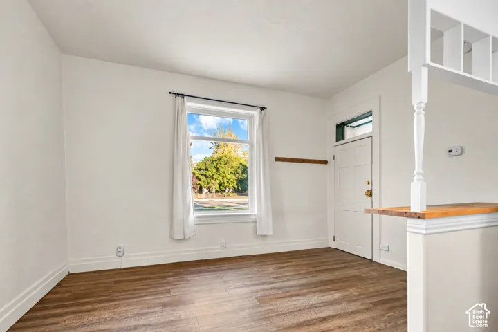 Wood-finish flooring, white walls, and a multi-pane window