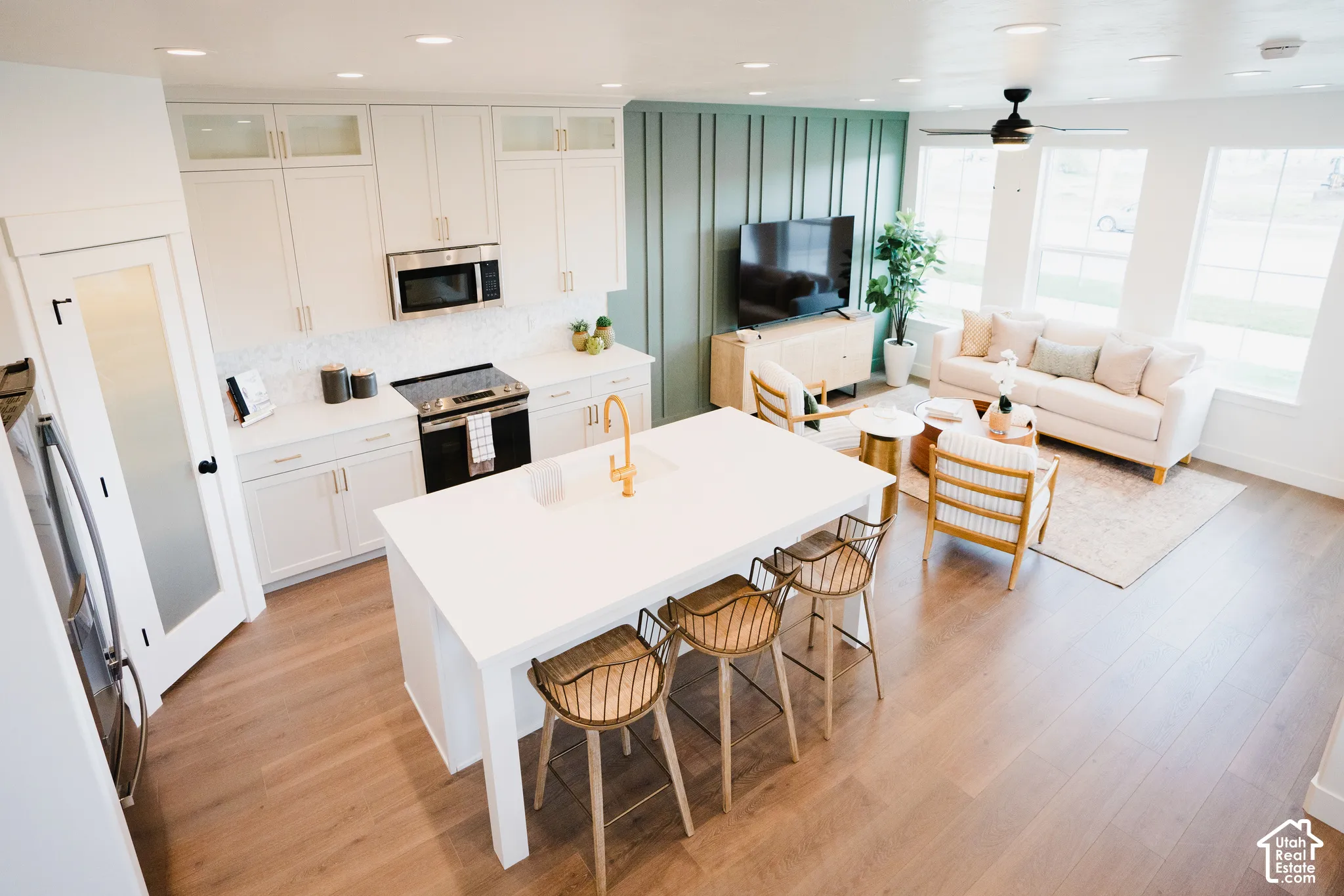 Kitchen featuring white cabinetry with gold-finish hardware, stainless steel appliances, and a central island