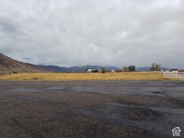 Expansive undeveloped land with a white post-and-rail fence