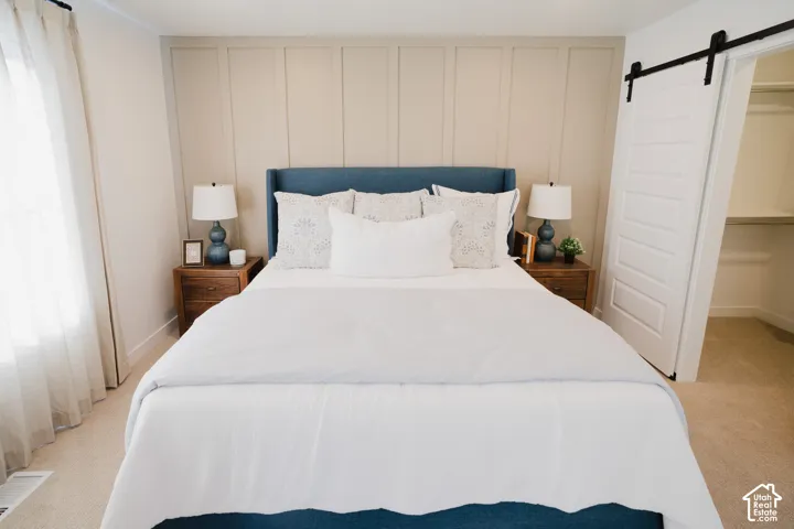 Board and batten accent wall, barn door entry, and carpeted flooring