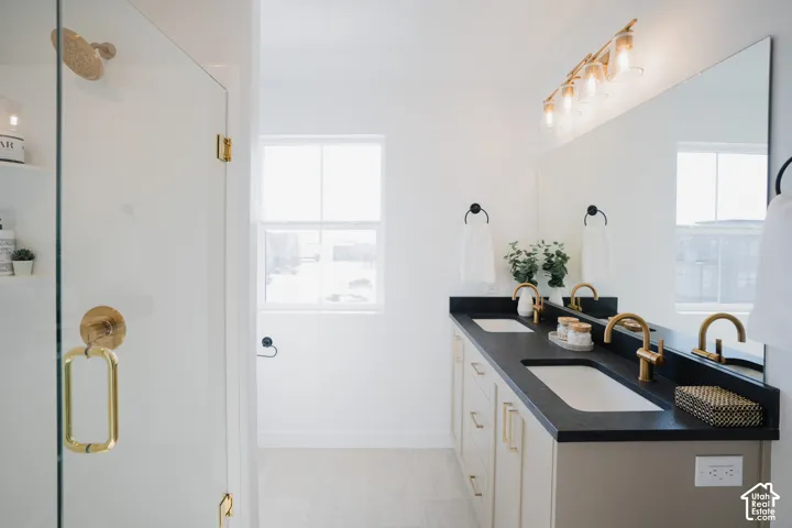 Dual vanity with undermount sinks, dark countertop, and gold-finish fixtures