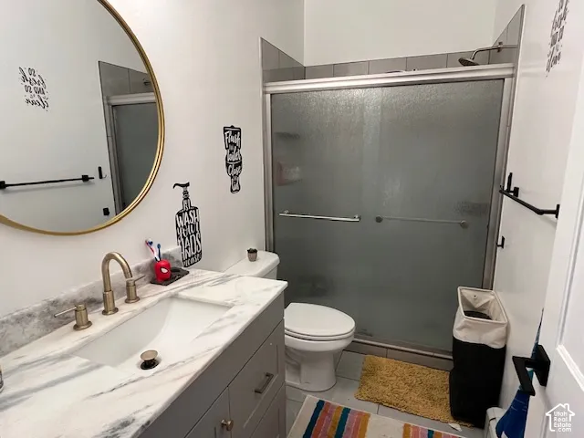 Vanity with a white vessel sink, a gold-tone faucet, and a stone-finish countertop