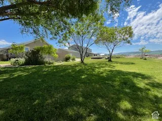 Expansive green lawn with mature trees and a distant mountain backdrop