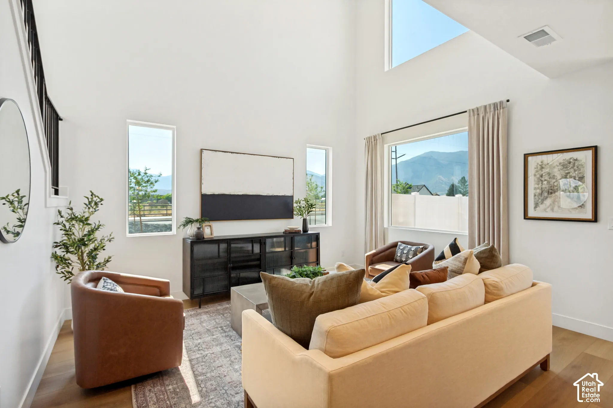 Vaulted ceilings and wood-finish flooring complement the white wall finishes