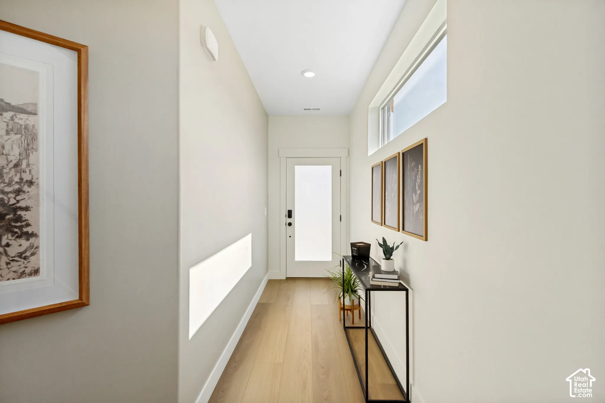 Hallway featuring wood-finish flooring, recessed lighting, transom windows, and a frosted glass door