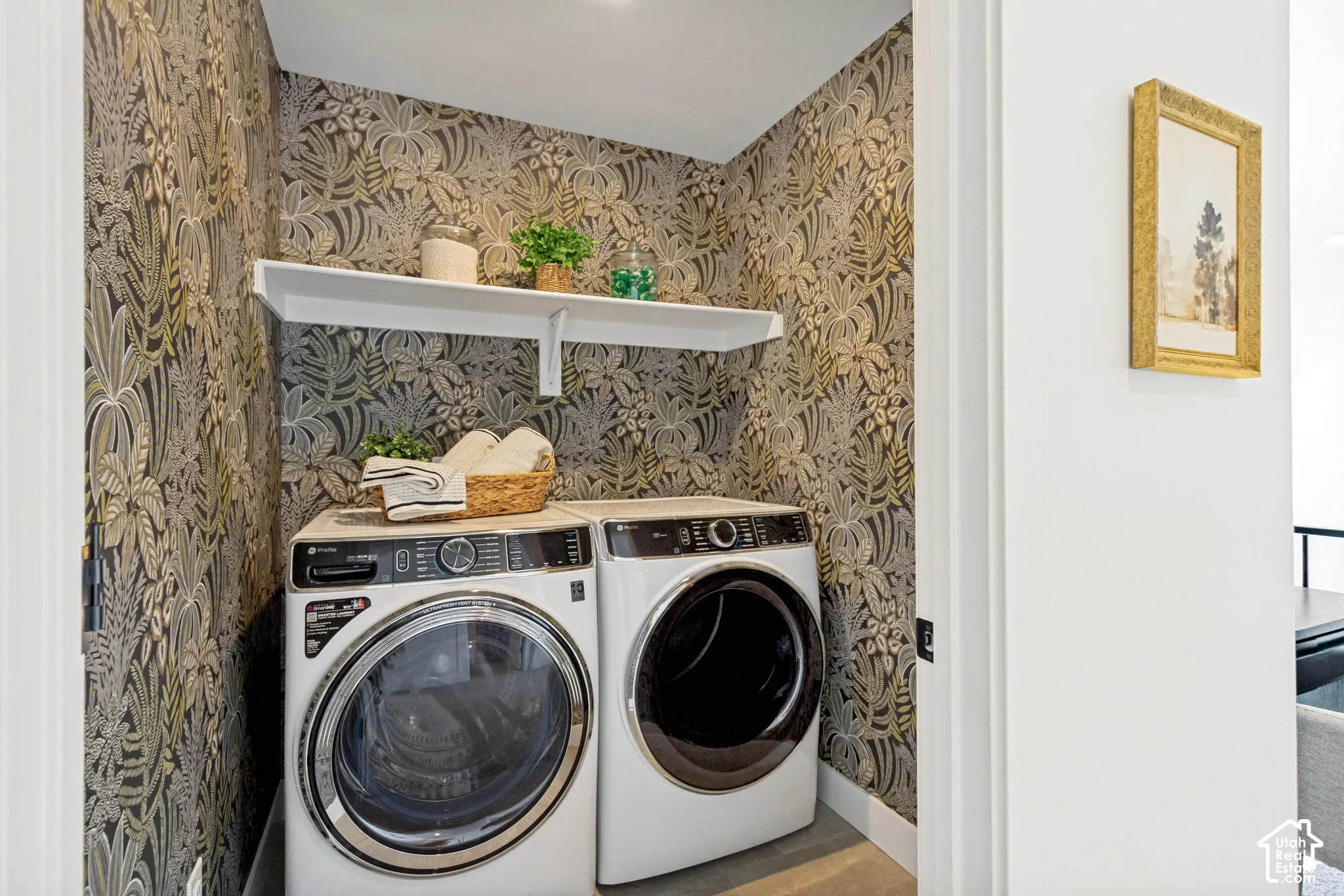 Dedicated laundry area with decorative wall covering and a built-in white shelf