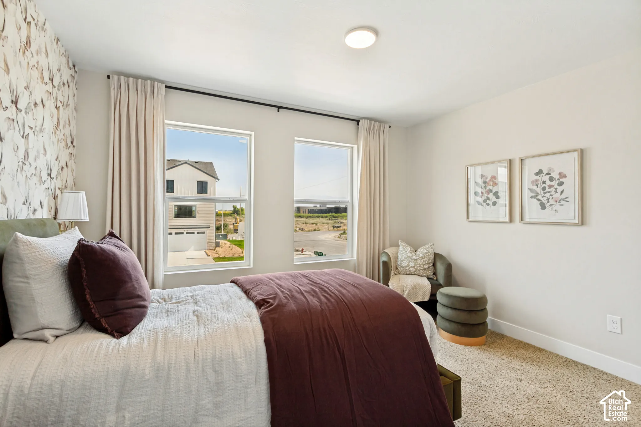 Textured accent wall, neutral wall paint, two large windows, flush mount ceiling light, and carpeted flooring