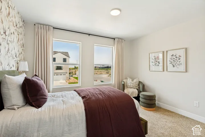 Textured accent wall, neutral wall paint, two large windows, flush mount ceiling light, and carpeted flooring