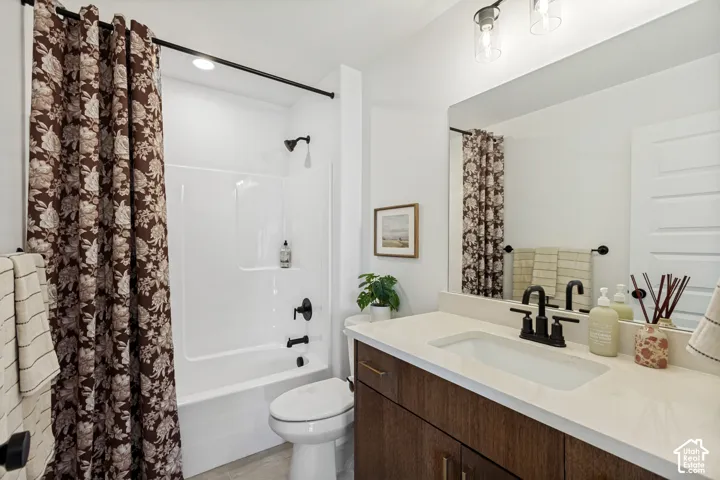 Built-in vanity with a single basin, light-toned countertop, wood-finish cabinetry, and matte black fixtures