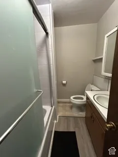 Integrated vanity with an oval sink, wood-finish cabinetry, and a framed mirror