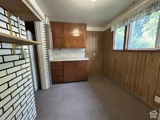 Wood-paneled walls with built-in cabinetry featuring upper and lower storage, complemented by a white countertop