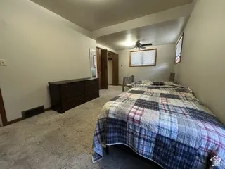 Recessed ceiling light, ceiling fan, window with blinds, wood-finish trim, and wall-to-wall carpeting