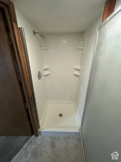 Walk-in shower with integrated shelving, chrome showerhead, and matching fixtures