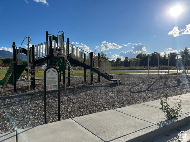 Community playground featuring slides, swings, and a climbing structure over a wood chip surface