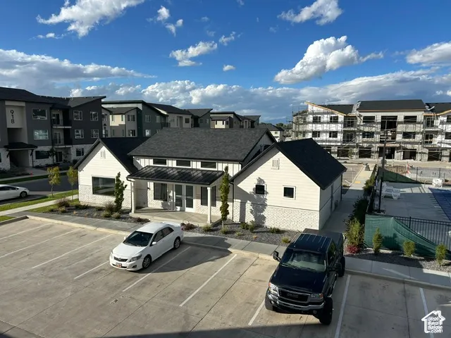 Property exterior featuring white siding, a dark pitched roof, and a covered entry
